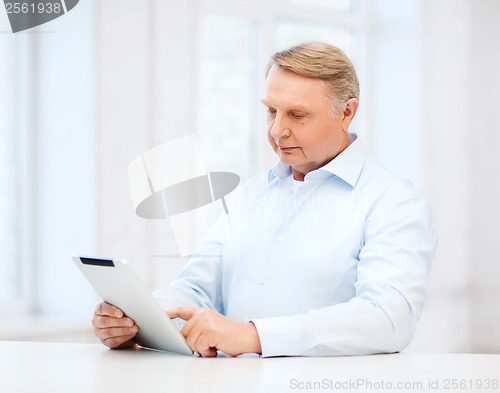 Image of old man with tablet computer at home