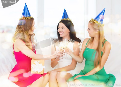 Image of three women wearing hats with champagne glasses