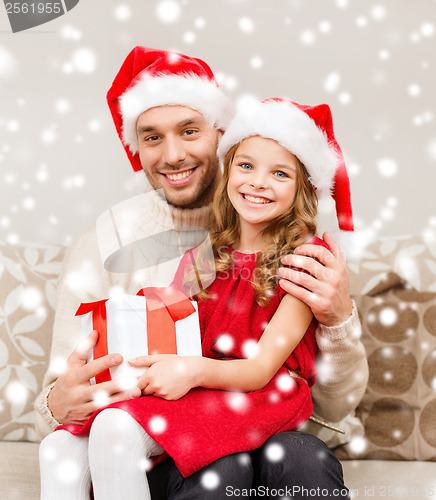 Image of smiling father and daughter holding gift box