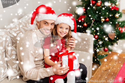 Image of smiling father and daughter holding gift box