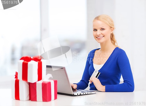 Image of woman with gifts, laptop computer and credit card