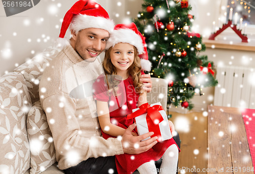 Image of smiling father and daughter holding gift box