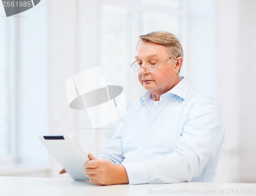 Image of old man with tablet computer at home