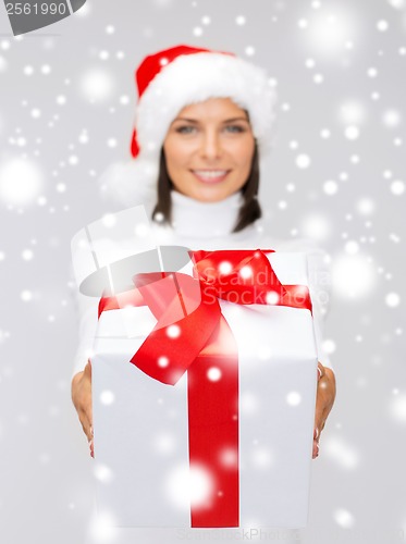 Image of woman in santa helper hat holding gift box