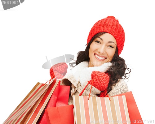 Image of smiling woman in warm clothers with shopping bags