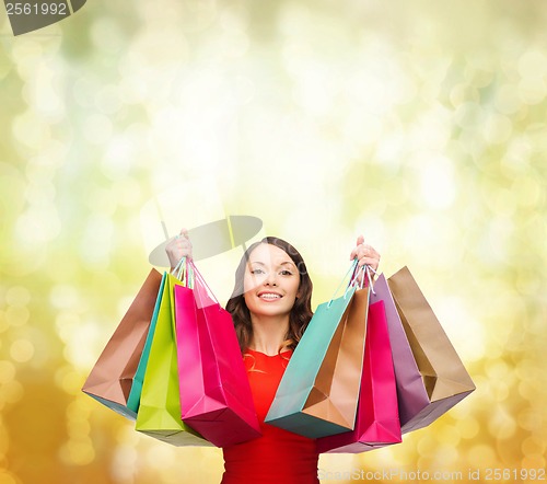 Image of woman in red dress with colorful shopping bags