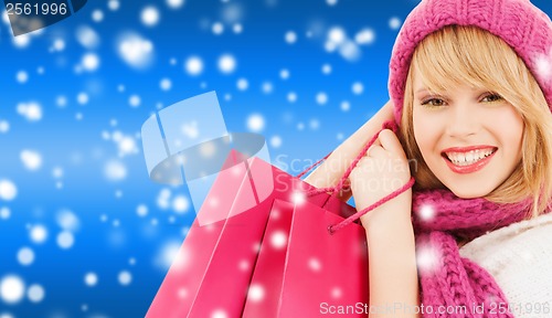 Image of woman in pink hat and scarf with shopping bags