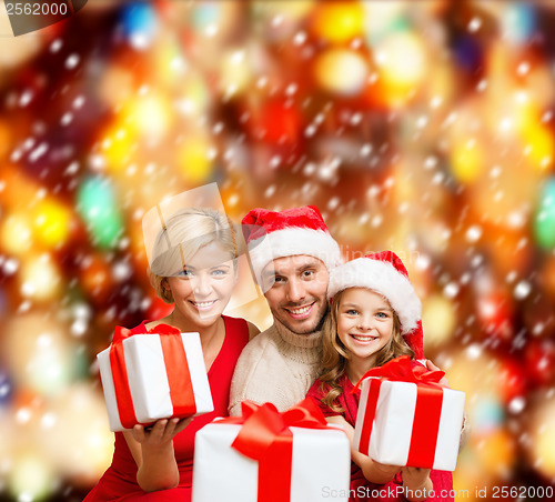 Image of smiling family giving many gift boxes