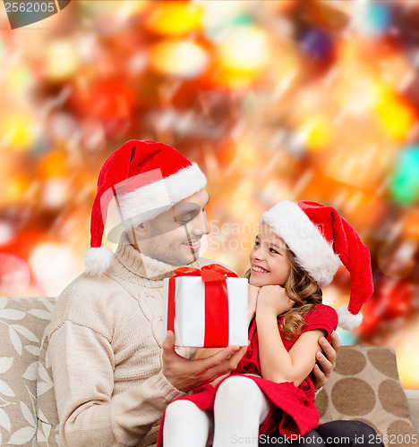 Image of smiling father giving daughter gift box