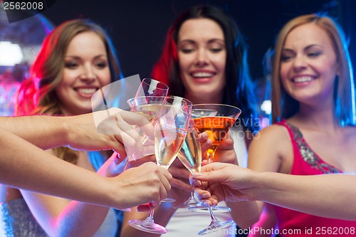 Image of three smiling women with cocktails and disco ball