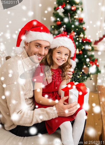 Image of smiling father and daughter holding gift box