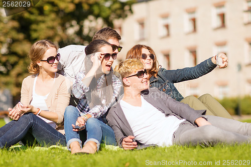 Image of teenagers taking photo outside with smartphone