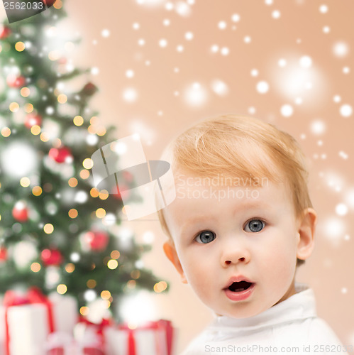 Image of happy little boy with christmas tree and gifts