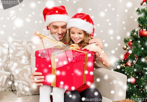 Image of smiling father and daughter opening gift box