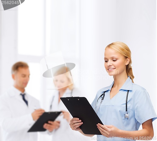 Image of smiling female doctor or nurse with clipboard