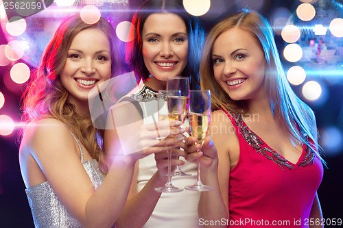 Image of three smiling women with champagne glasses