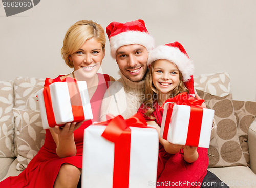 Image of smiling family giving many gift boxes