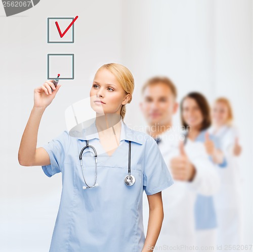 Image of doctor or nurse drawning checkmark into checkbox