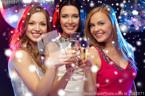 Image of three smiling women with champagne glasses