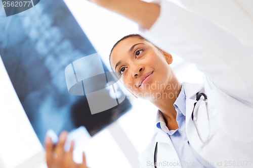 Image of smiling female doctor studying x-ray