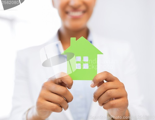 Image of woman hands holding green house