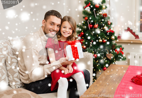 Image of smiling father and daughter holding gift box