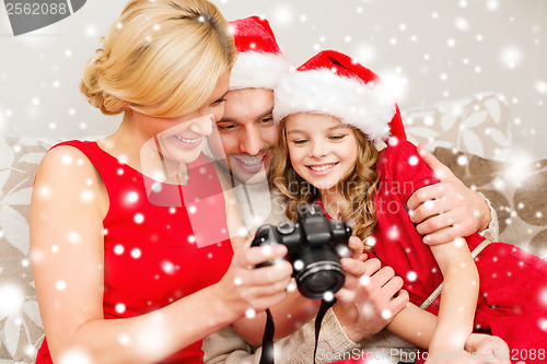 Image of family in santa helper hats looking at pictires