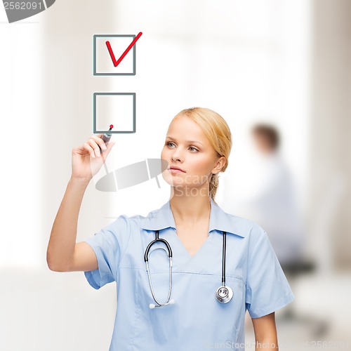 Image of doctor or nurse with marker drawning red checkmark