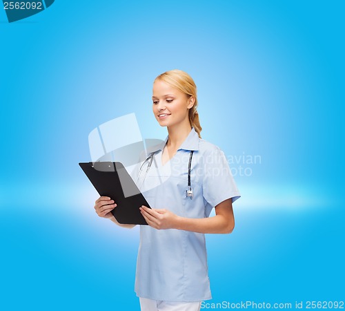 Image of smiling female doctor or nurse with clipboard