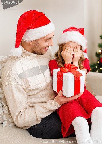 Image of smiling daughter waiting for a present from father