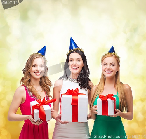 Image of three smiling women in blue hats with gift boxes