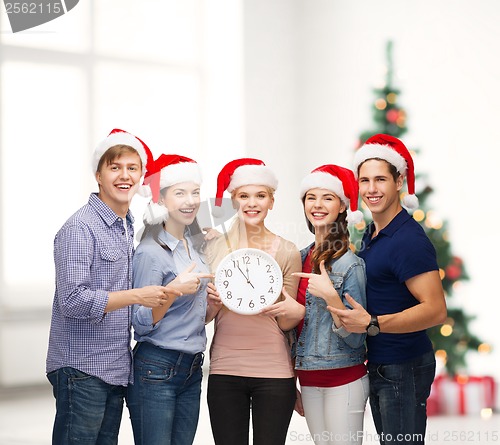 Image of group of smiling students with clock showing 12