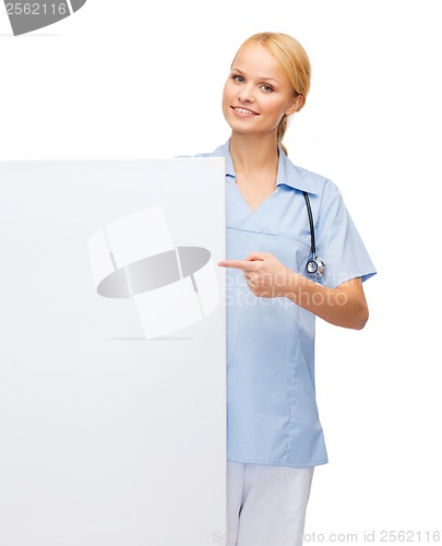 Image of smiling female doctor or nurse with blank board