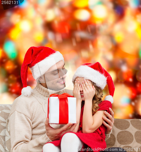 Image of smiling daughter waiting for a present from father