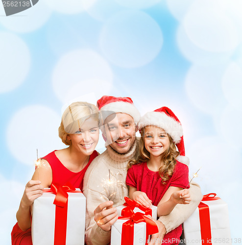 Image of smiling family holding gift boxes and sparkles