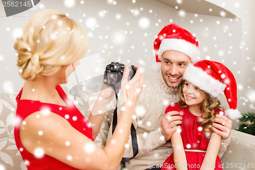 Image of mother taking picture of father and daughter