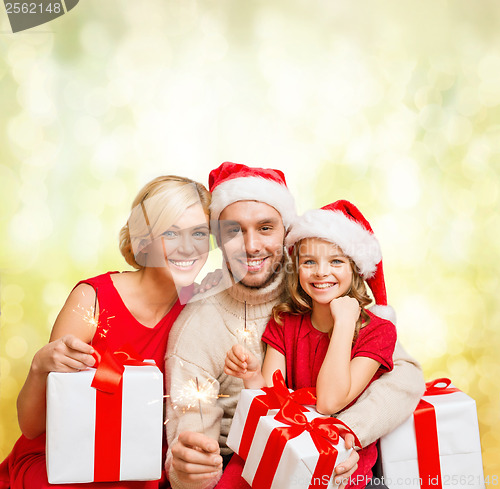 Image of smiling family holding gift boxes and sparkles