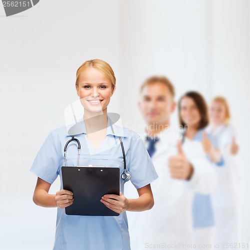 Image of smiling female doctor or nurse with clipboard