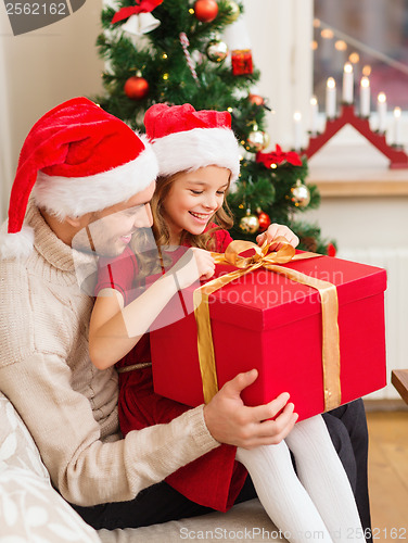 Image of smiling father and daughter opening gift box