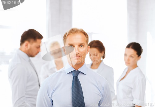 Image of businessman in office with group on the back