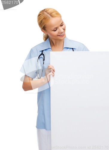 Image of smiling female doctor or nurse with blank board