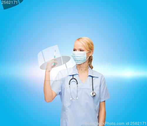 Image of female doctor or nurse in mask holding syringe