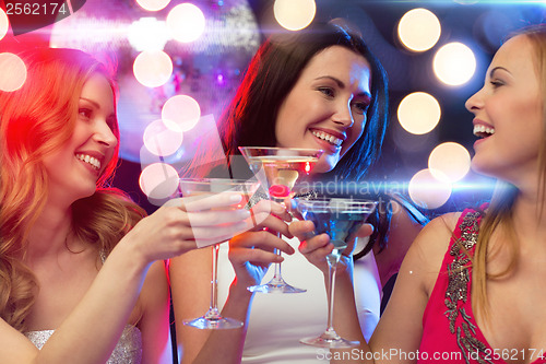 Image of three smiling women with cocktails and disco ball