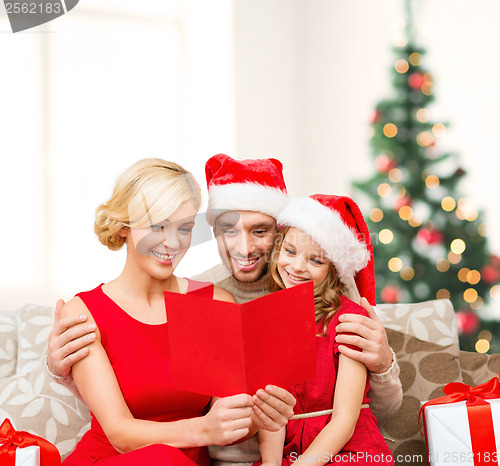 Image of smiling family reading postcard