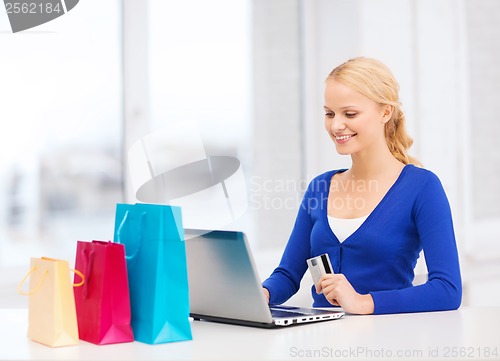 Image of woman with laptop, shopping bags and credit card