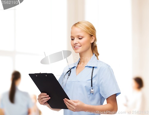 Image of smiling female doctor or nurse with clipboard