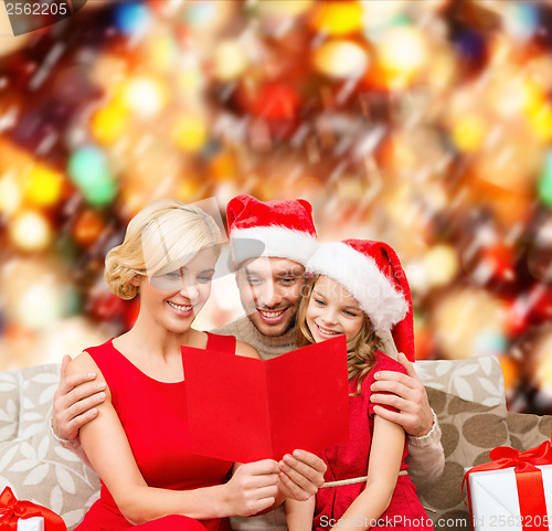 Image of smiling family reading postcard