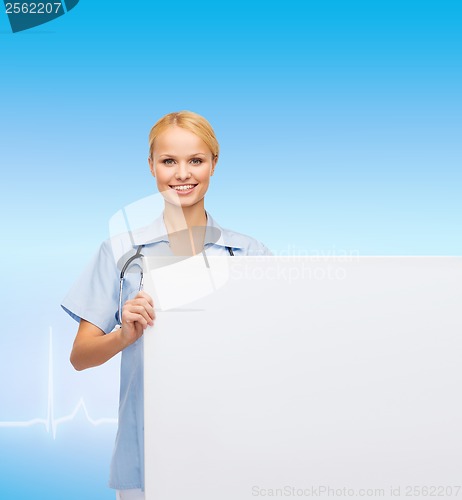 Image of smiling female doctor or nurse with blank board