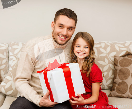 Image of smiling father and daughter holding gift box