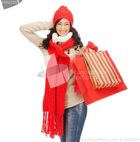 Image of smiling woman in warm clothers with shopping bags
